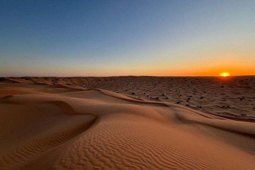 A desert landscape with sand dunes and a sunset. 5