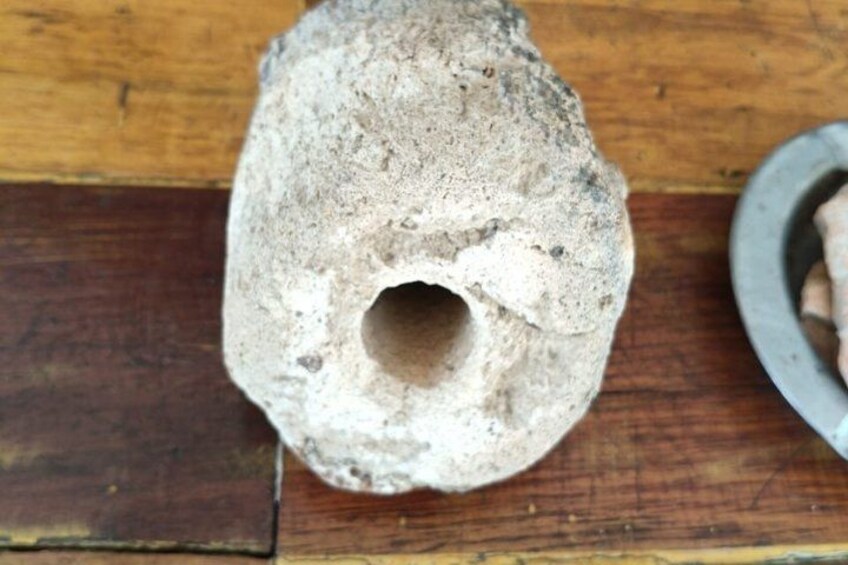 A rough-textured stone with a hollow center, placed on a wooden surface. 5