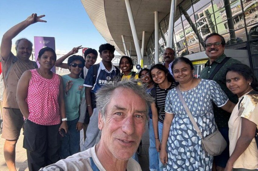 A group of people standing in front of a modern building with a glass facade. 2