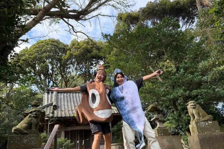 Two people in costumes, a stone structure, and trees in the background. 3