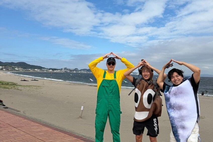 Three people on a beach with a clear sky and ocean in the background. 5