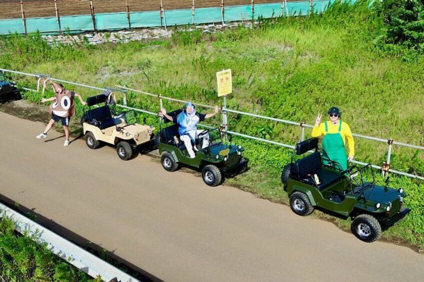 People in small vehicles on a paved path. 2