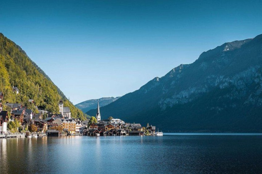A lakeside village with houses, a church, and mountains in the background. 5