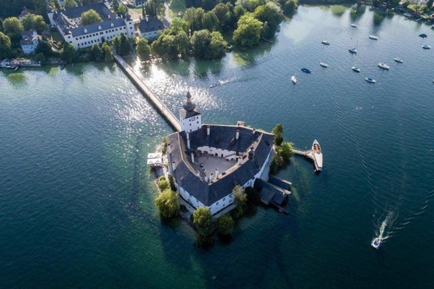 An aerial view of a circular island with a central building, surrounded by water and boats. 2