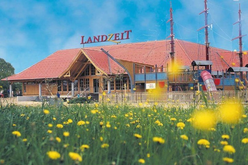 A building with a red roof and the sign 'LANDZET' above it. 3