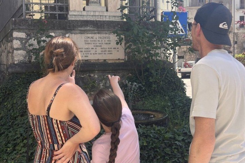 A group of people standing in front of a historical plaque. 3