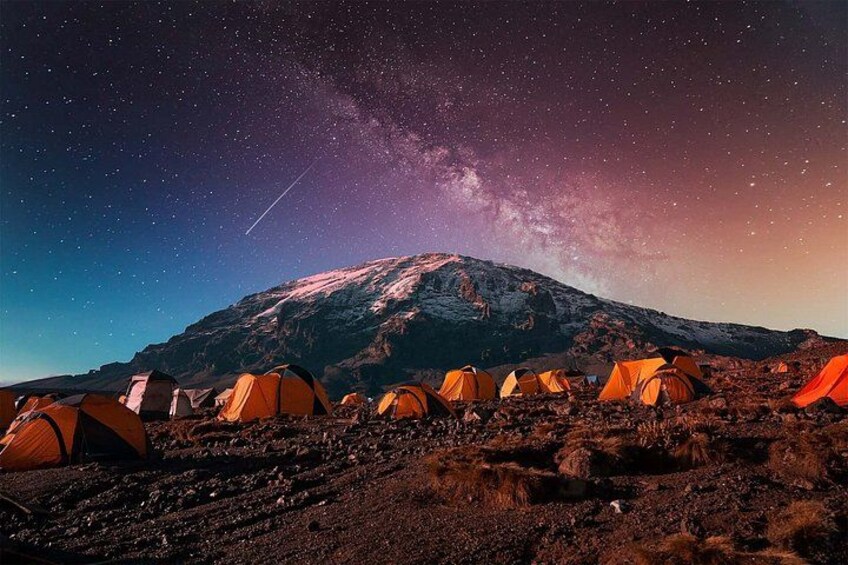 A mountain with tents and a starry sky. 1