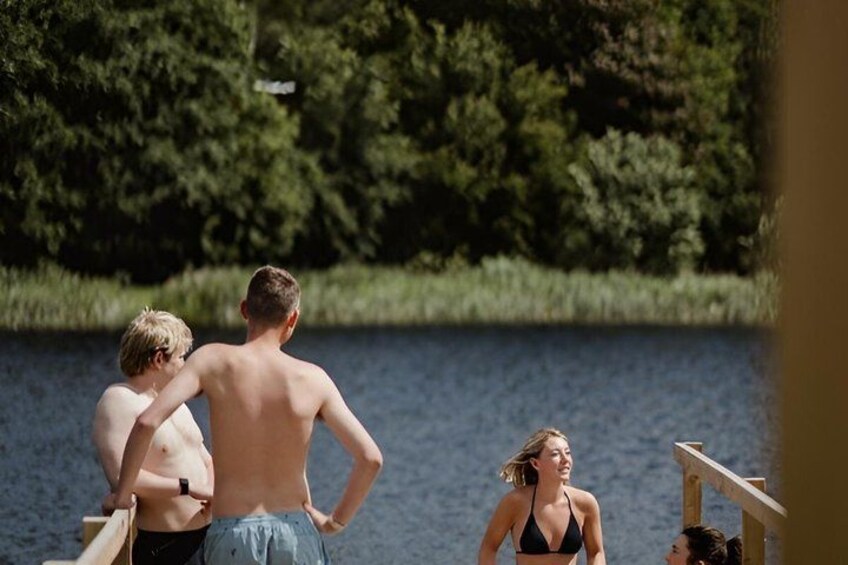 A lake with people standing on a dock. 3