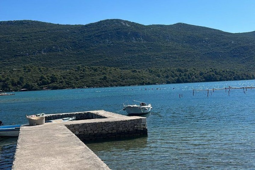 A calm lake with a dock, a small boat, and a mountainous backdrop. 4
