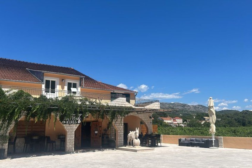 A building with a tiled roof, outdoor seating, and a statue. 2