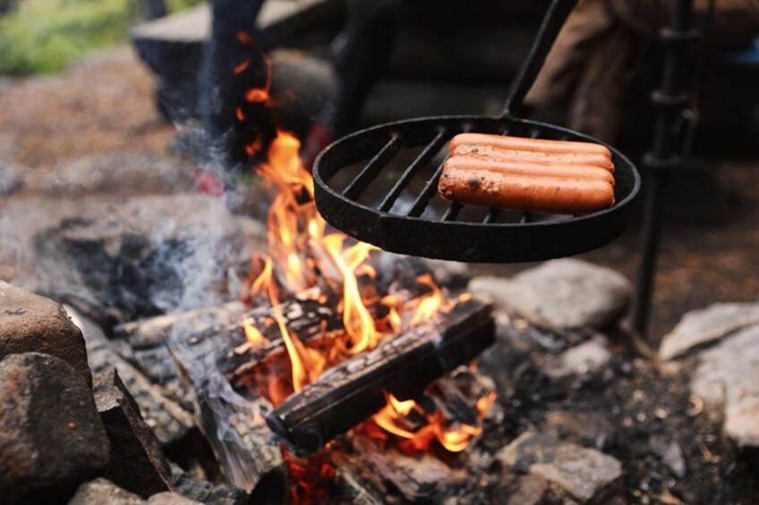 A hot dog being grilled over an open fire. 4