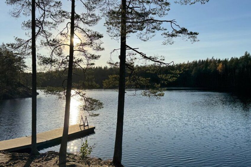 A wooden dock extending into a calm lake surrounded by trees. 1