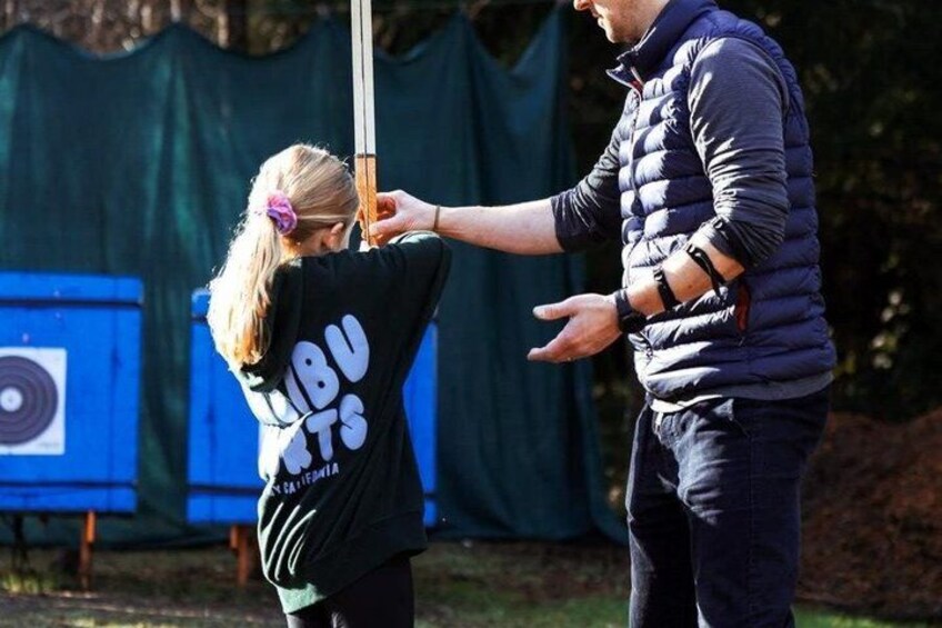 A person in a black shirt with white text, holding a stick, and another person in a blue jacket gesturing. 4