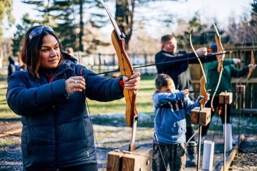 An archery range with participants in blue jackets. 2