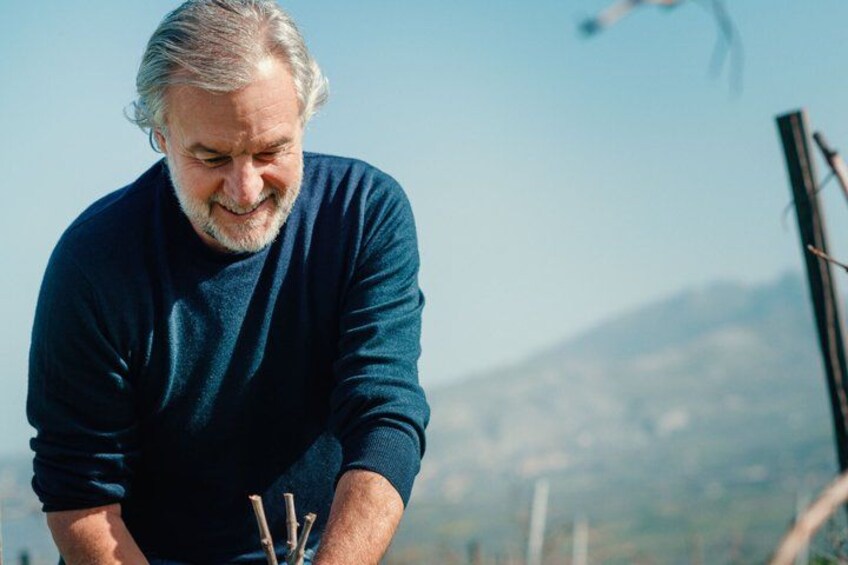 A person in a dark sweater near a wooden structure with a mountainous background. 2