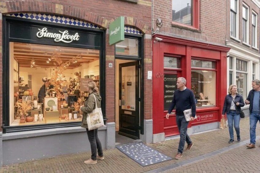 A street with a Simon Levitt store and a red building with a sign. 5
