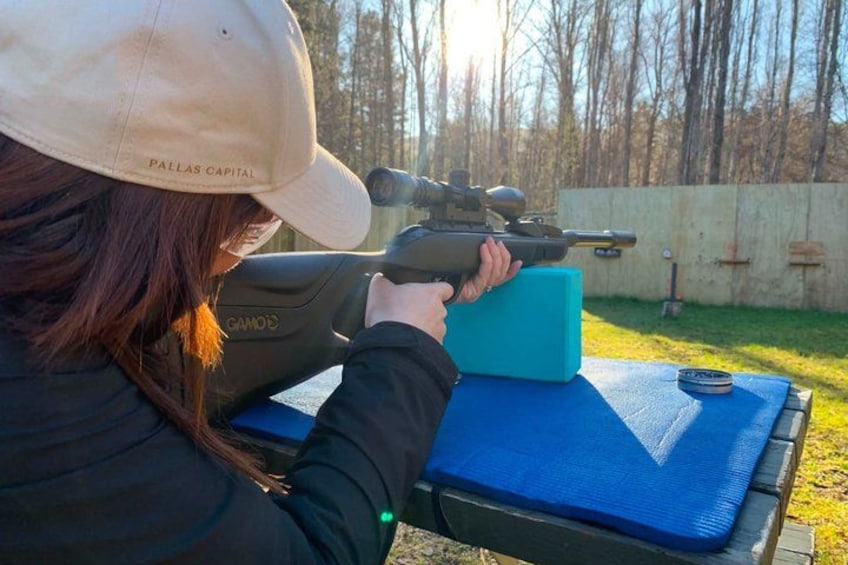 A person aiming a rifle at a target. 3