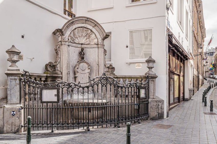 A white building with a decorative iron gate and a clock. 2