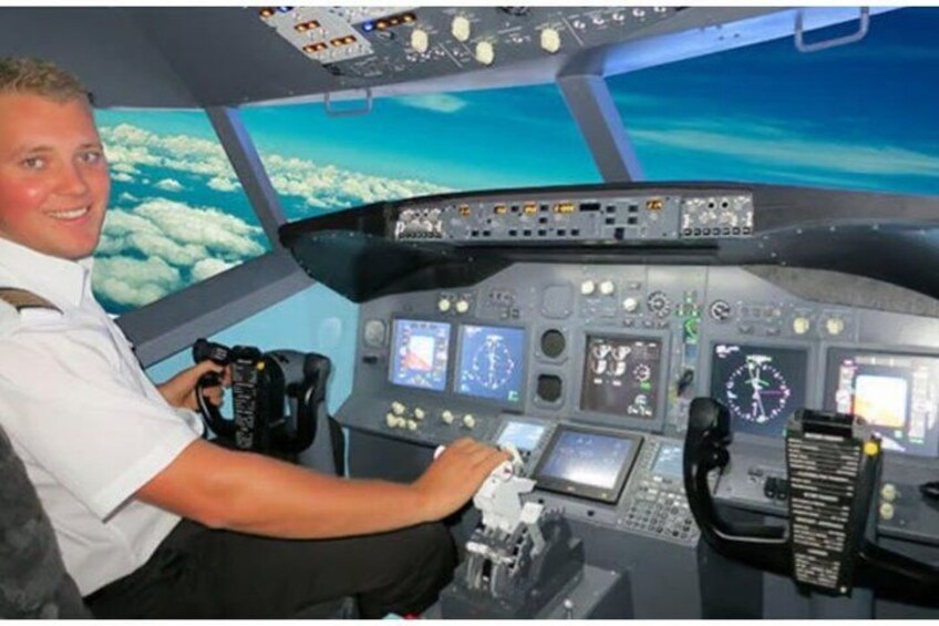 A cockpit with multiple screens, a control panel, and a person operating the controls. 1