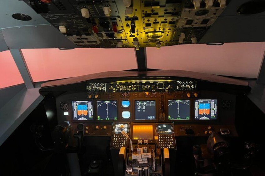 A cockpit with multiple screens and control panels. 4