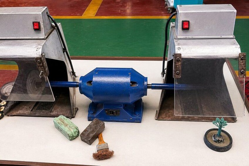 A blue electric motor connected to two metal workbenches with red emergency stop buttons. 3