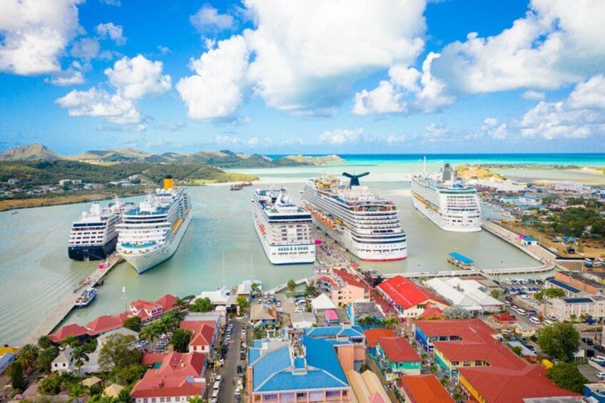 A harbor with multiple cruise ships docked, a bridge, and a coastline with hills. 5
