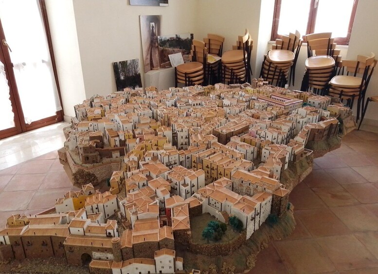 Une maquette détaillée d’une ville, comprenant de nombreux bâtiments disposés selon un plan en forme de grille. 3