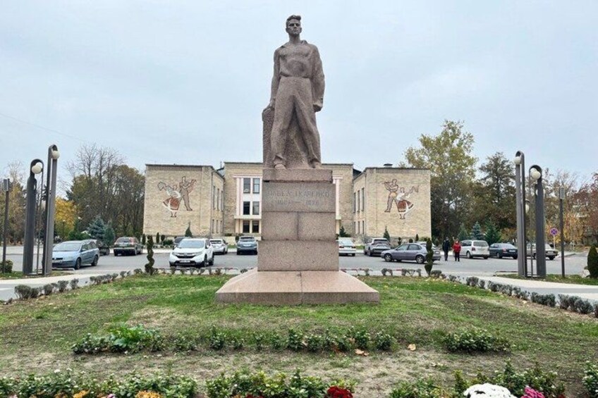 A statue in a park with a building in the background. 3