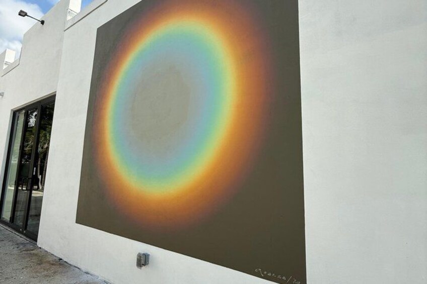 A large mural of a rainbow on a building wall. 3