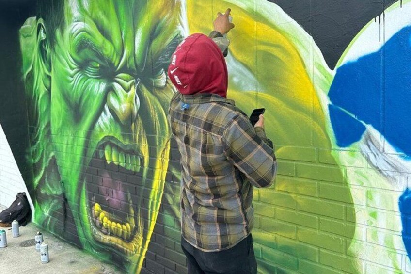 A person painting a mural on a brick wall. 5