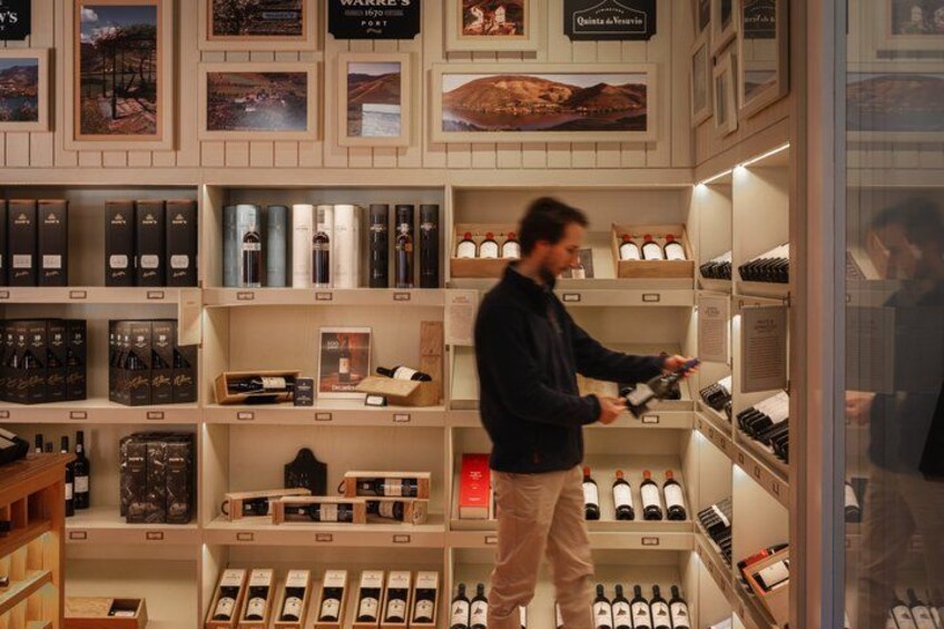 A person browsing wine bottles in a store. 2