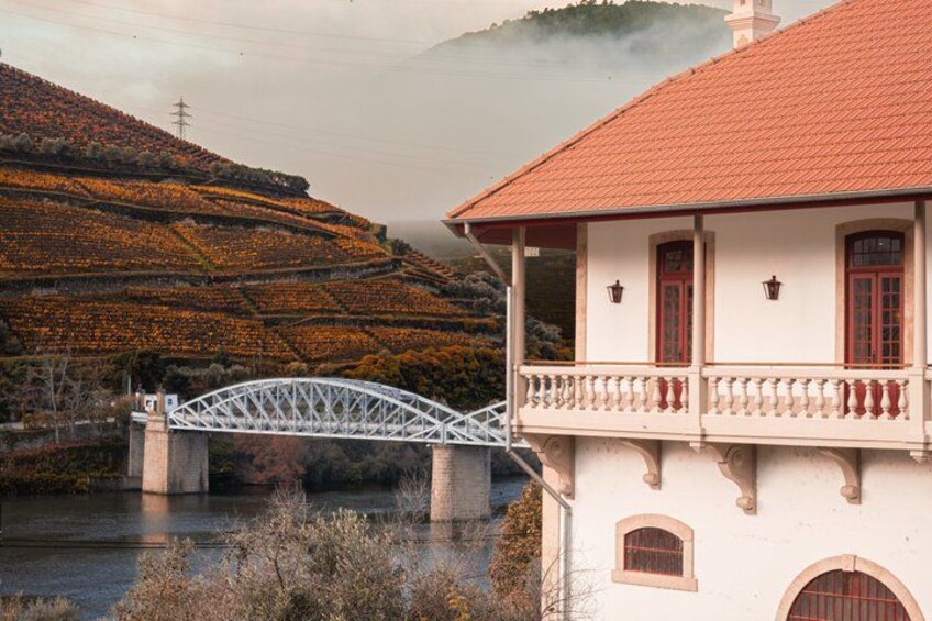 A white building with a red roof, a white bridge, and a river. 5