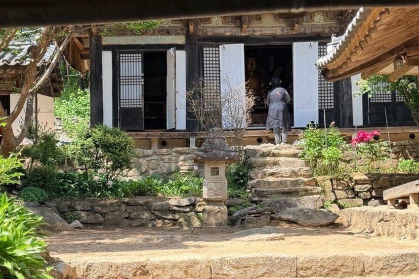 A traditional Korean building with a stone staircase leading up to a wooden door. 4