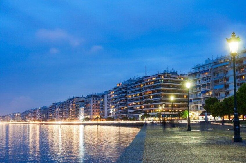 A waterfront cityscape at dusk with illuminated buildings and a calm river. 3