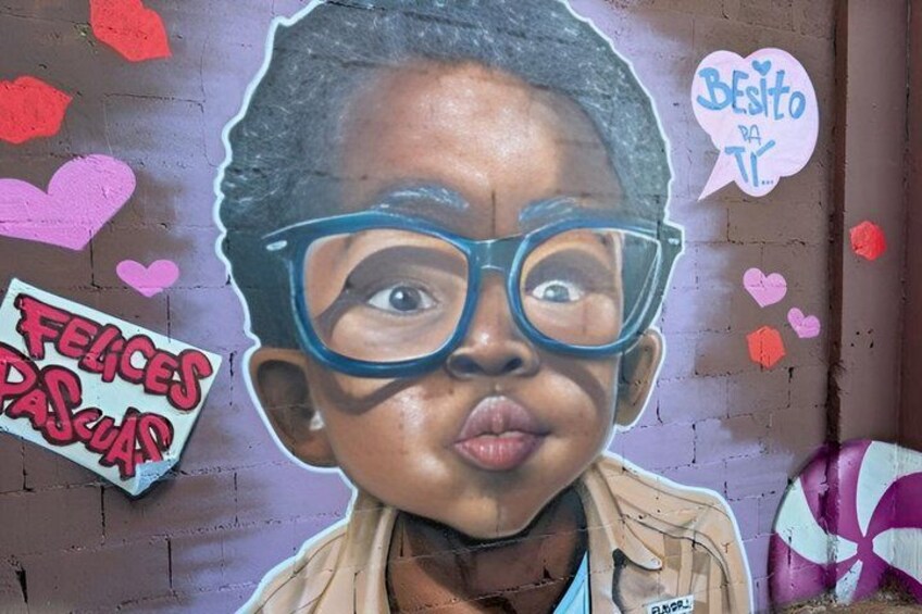 A mural with a child, hearts, and text saying 'Felices Pascuas'. 5