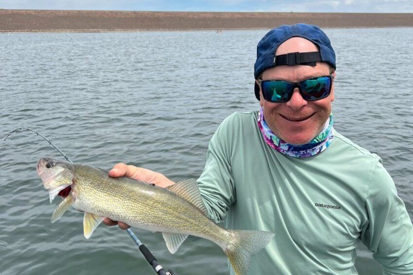 A person holding a fish with a fishing rod. 5