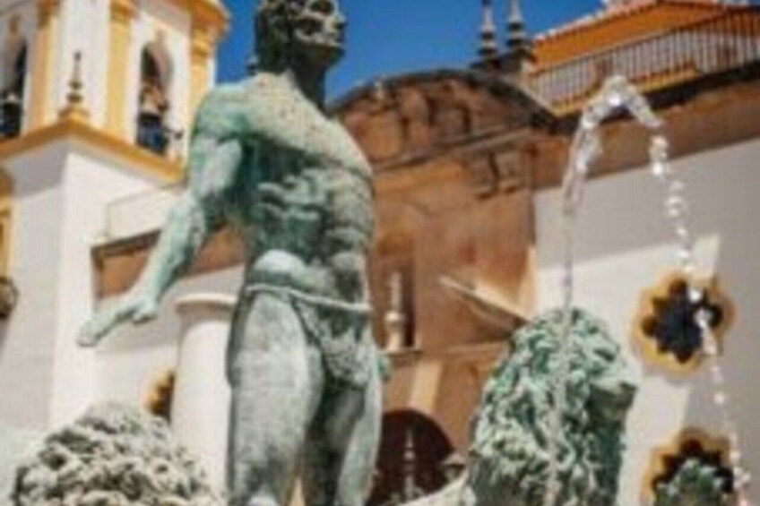 A statue of a muscular figure in a classical pose, a fountain, and a building with ornate architecture. 4