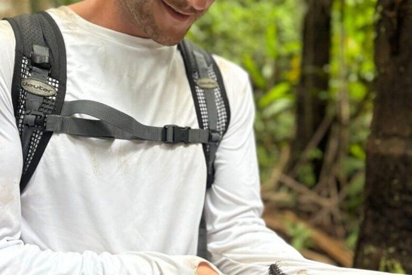 A person wearing a white long-sleeve shirt and a black backpack with a hydration system. 2