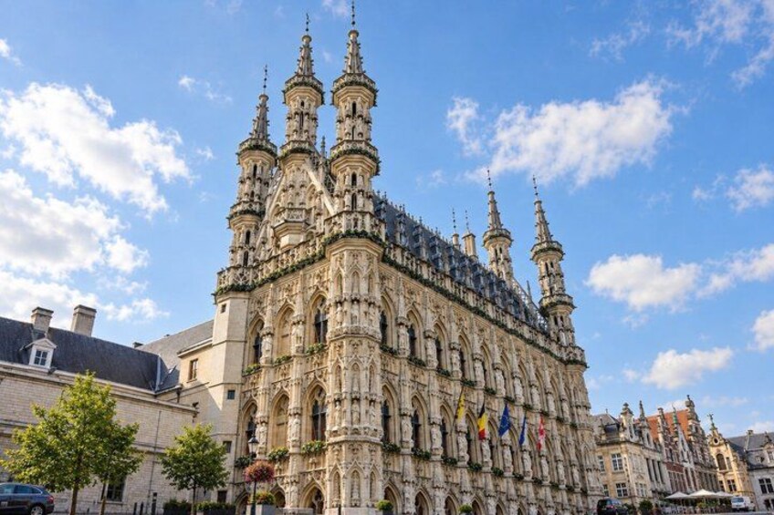 A historic building with intricate architecture, multiple spires, and flags. 3