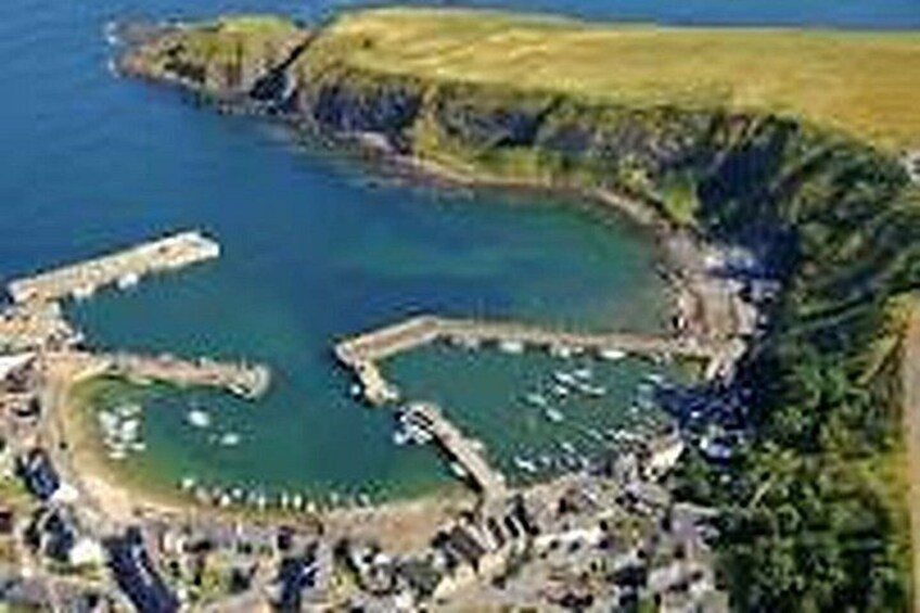 A coastal area with a bay, a small harbor, and a cliff. 2