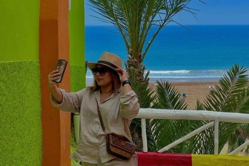 A person taking a selfie with a beach and ocean in the background. 5
