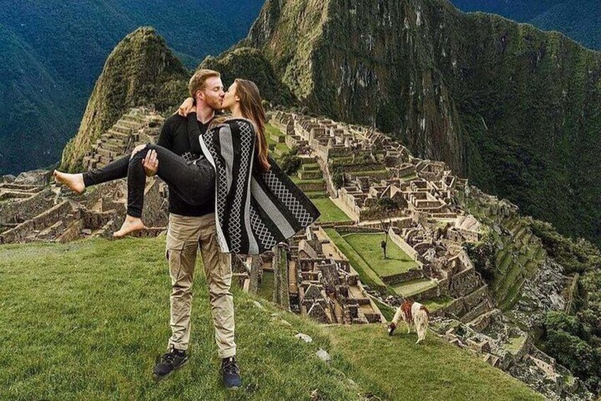 A couple embracing in front of Machu Picchu with the ruins and surrounding mountains in the background. 2