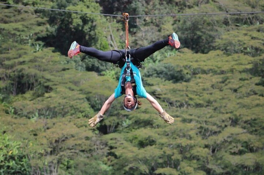 A person in a blue and black outfit suspended in mid-air, performing an aerial maneuver with a bungee cord. 5