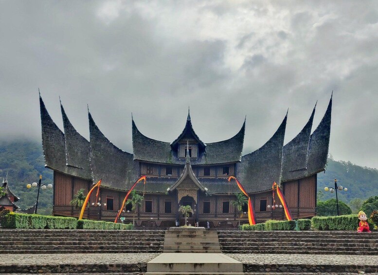 A traditional building with a steeply pitched roof and multiple spires, surrounded by stone steps and greenery. 3
