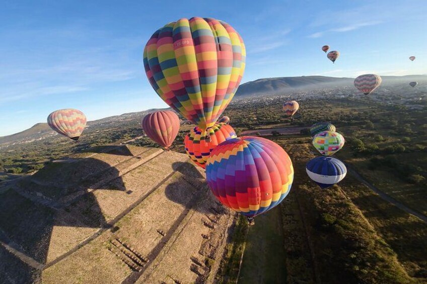 Hot air balloons over a landscape with mountains and a clear sky. 1