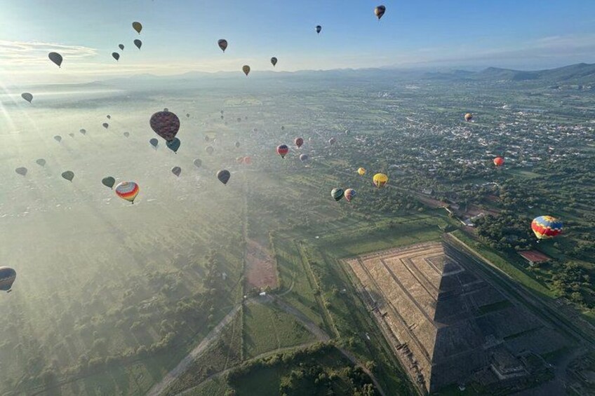 A landscape with hot air balloons in the sky. 2