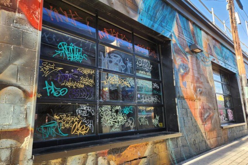 A window with multiple graffiti artworks. 3