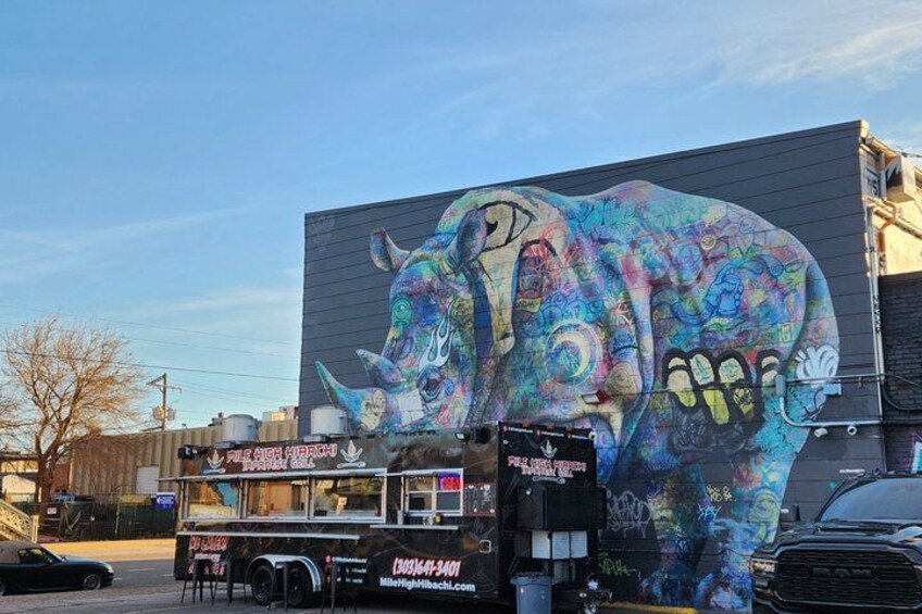 A colorful elephant mural on a building with a food truck in front. 5