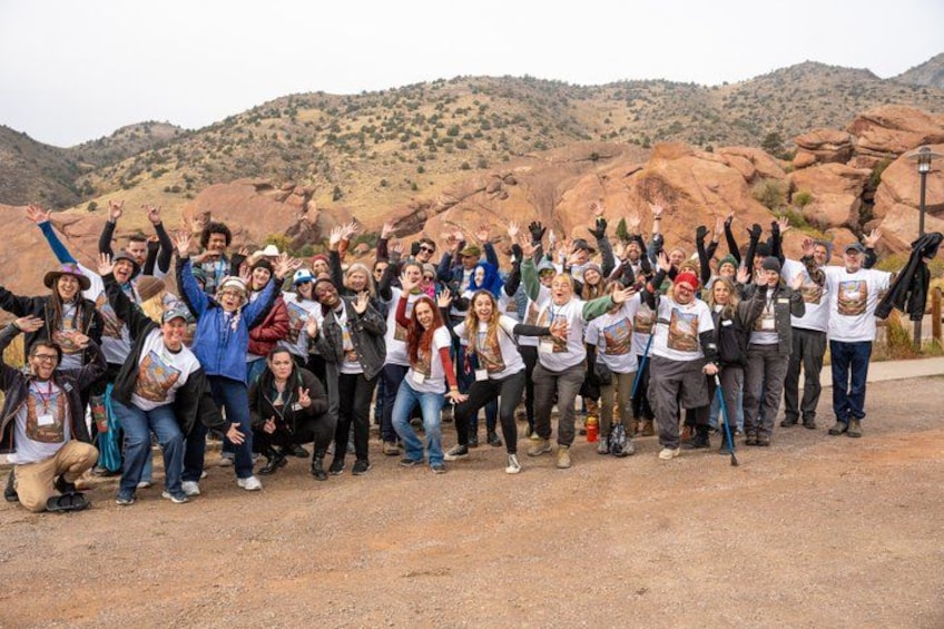 A group of people posing in a rocky outdoor setting with mountains in the background. 5