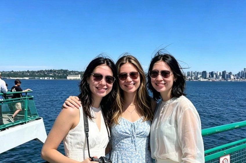 Three people on a boat with a city skyline in the background. 1